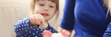 Child little girl putting coin money into piggy bank containerの写真素材