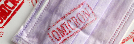 Protective medical face mask with omicron virus infection stamp closeupの写真素材