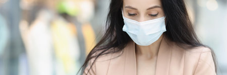 Woman in face mask look in wallet, female being short of moneyの写真素材