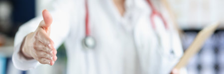Doctor woman give hand to greet someone, medical worker in uniform happy to see patientの写真素材