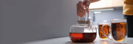 Black tea in a transparent teapot and cups closeupの写真素材