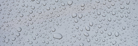 Closeup of raindrops on gray window glass texture background