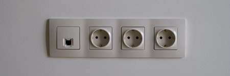 Electric socket on white wall closeup. Sockets with antenna cable and internet