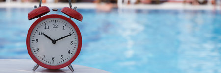 Red alarm clock for ten oclock near pool in hotel or spa center
