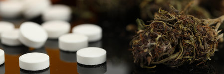 Marijuana buds and white pills rest with cbdの写真素材
