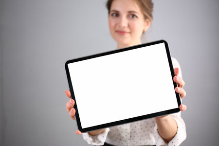 Smiling beautiful woman is holding advertising tabletの写真素材