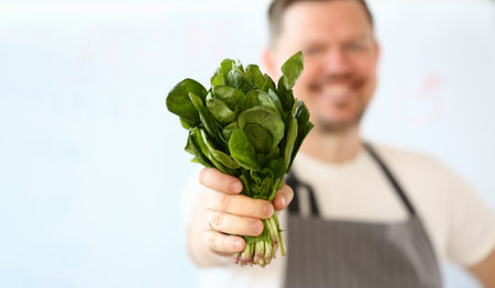 Smiling cook is holding lettuce or sorrel leaves closeupの写真素材