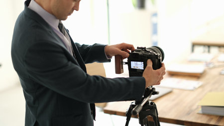 Man in suit business blogger adjusting camera in conference room