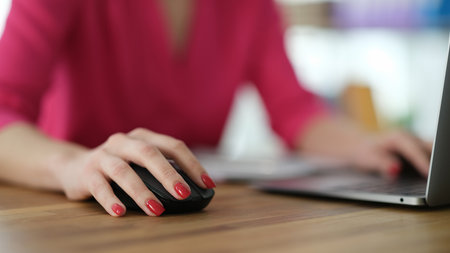 Hand of businesswoman working at computer using mouse closeupの写真素材