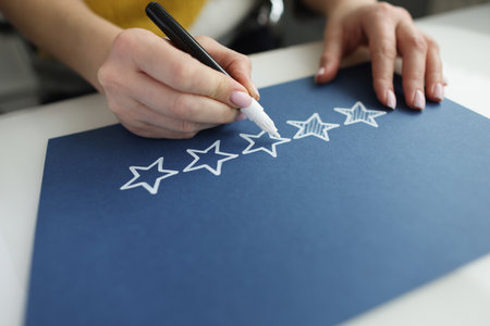 Person draws feedback feedback stars with star markerの写真素材