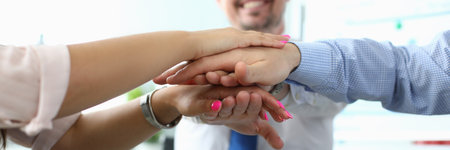 Business people put their hands together in office closeup