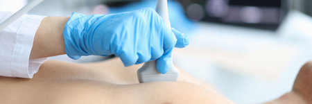 Doctor makes echocardiography of male patient using ultrasound probe pressing on patient chestの写真素材