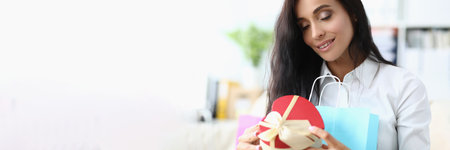 eautiful young woman enjoying gift at homeの写真素材