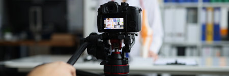 Videographer filming online broadcast about medicine in clinic with doctorの写真素材
