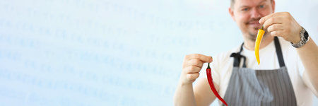 Cook is holding red and yellow hot chili peppersの写真素材