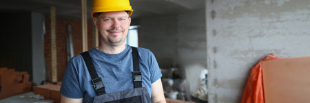 Smiling handsome male builder in hardhat holding pen and clipboardの写真素材