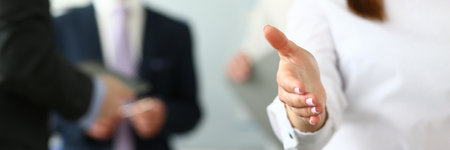 Friendly young company representative extends hand for handshakeの写真素材