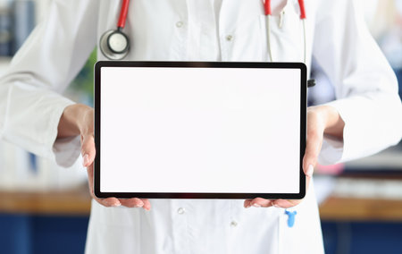 Doctor holds tablet with white screen in medical officeの写真素材