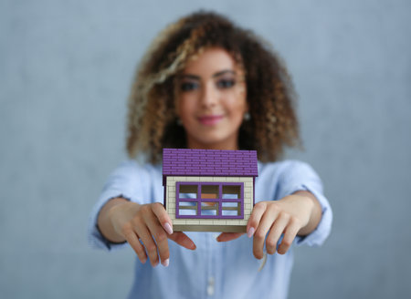 Beautiful black woman portrait. Holds a miniatureの写真素材