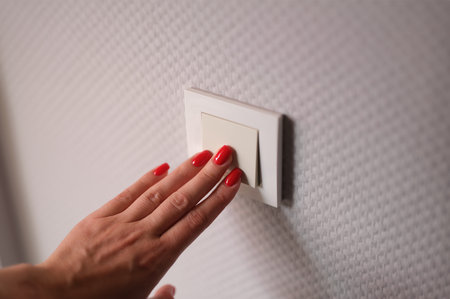 Closeup of woman hand is turned off on light switch at homeの写真素材