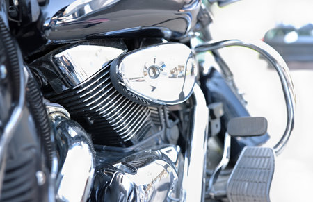 Metallic shiny parts of black motorcycle on street.