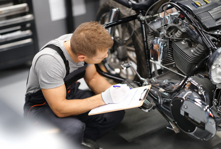 Foreman in service repair center diagnoses parts on motorcycle