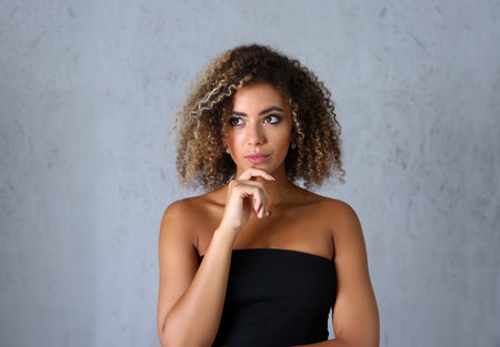 Portrait of a pensive latino woman looks up mysteriously