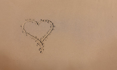 Drawn heart on wet sand next to seaの写真素材