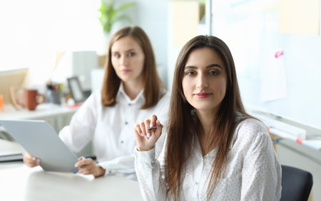 Portrait of joyful businesswoman sitting in modern workplaceの写真素材