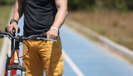 Man with mountain bike standing on bicycle path closeupの写真素材