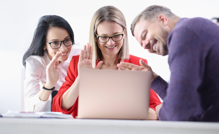 Group of business people waving laptop screen