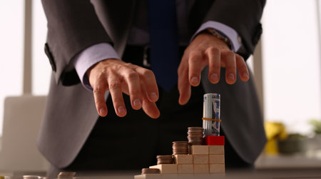 Male arm in suit reach for money closeupの写真素材