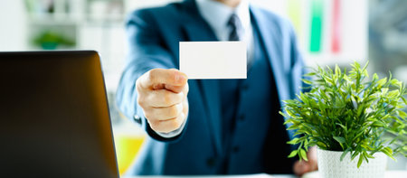 Male arm in suit give blank calling cardの写真素材