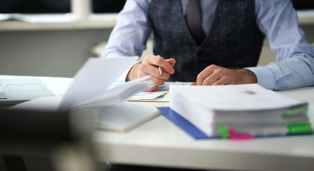 Clerk man at office workplace with silver pen in armsの写真素材