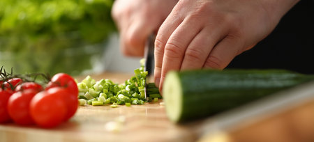 Cook holds knife in hand and cuts onの写真素材