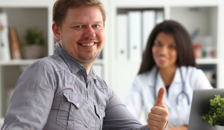 Man showing ok sign with thumb up at physicianの写真素材