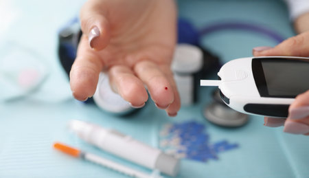 Doctor check blood sugar level of client use digital glucometer at hospitalの写真素材