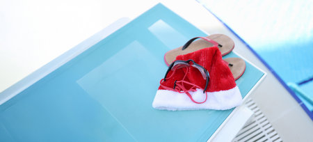 Hat of Santa Claus, swimming slippers on sunbedの写真素材