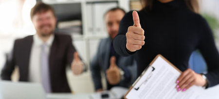 Group of young businesspeople happy to make good deal show thumbs up