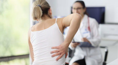 Female patient complain on back pain and touch side of body