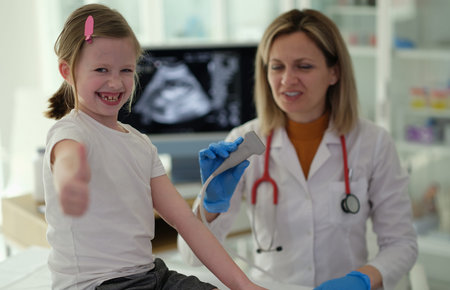 Young girl smiles brightly while receiving care from a friendly doctor in a bright medical office...
