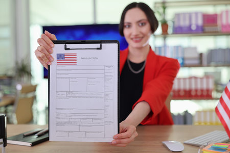 Professional woman showcasing a completed application form in a vibrant office setting during...