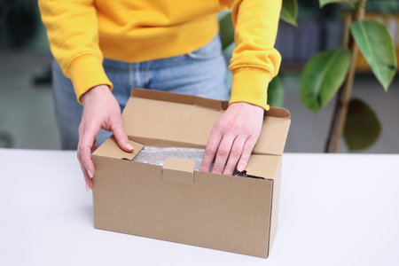 Exciting moment of unboxing a surprise package in a cozy indoor setting during a sunny afternoon