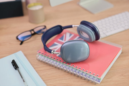 Creative workspace with stylish headphones, a notebook, and glasses at a cozy deskの写真素材