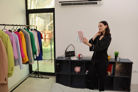 Model showcases colorful outfit selection in a chic dressing room filled with natural light and...
