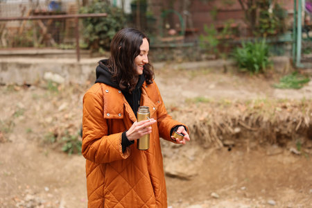Warm smiles on a chilly day while enjoying a stroll with a thermos in hand and nature all around