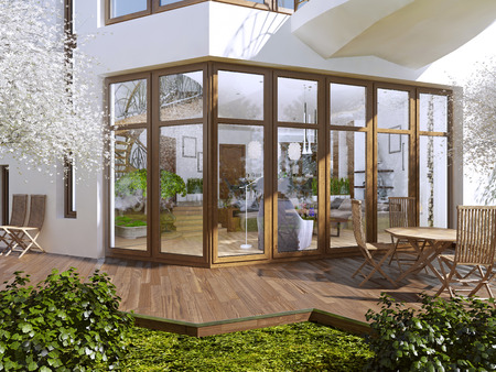The sun terrace of a private house. Boardwalk terrace with table and chairs. Large panoramic windows overlooking the garden with a terrace. 3D render.の写真素材