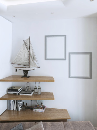 Suspended wooden shelves with decorative items for the interior. A large model of a sailboat in the modern stilde. Mockup poster on the wall. 3D render.の写真素材