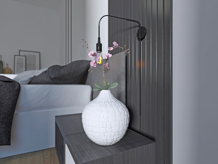 Designer bedside table with decor in a modern black and white bedroom. 3D render.の写真素材