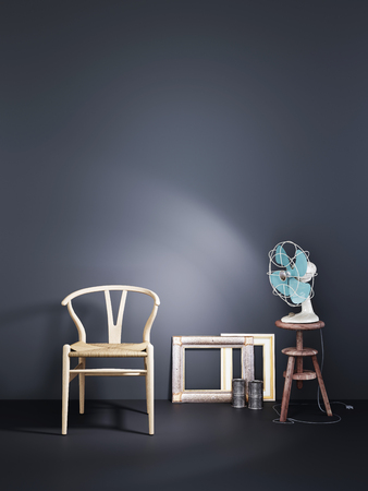 Empty wall with wooden chair and air fan in a blac wall background dark modern interior, 3D renderingの写真素材